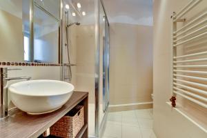 La salle de bains est pourvue d'un lavabo blanc et d'une douche. dans l'établissement Grand Apartments - Brooklyn 2 bedroom apartment, à Sopot
