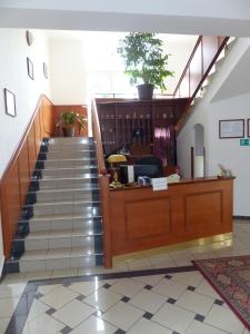 a lobby with a staircase with a potted plant at Penzion Harmonie in Chodov