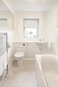 a white bathroom with a toilet and a sink at Struan House in Inverkeithing