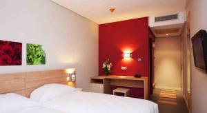 A bed or beds in a room at Manzil Hotel