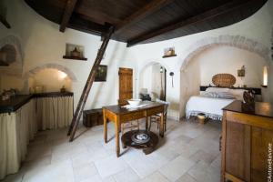 ein Schlafzimmer mit einem Bett und einem Tisch in einem Zimmer in der Unterkunft Rione Pentimi in Alberobello
