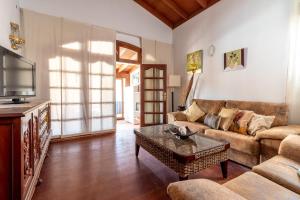 een woonkamer met een bank en een tafel bij Flatguest Chozo del viejo - Peaceful country Villa in La Antigua in Valle de Santa Inés