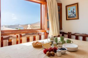 a table with plates and fruit on it with a window at Flatguest Chozo del viejo - Peaceful country Villa in La Antigua in Valle de Santa Inés