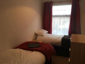 a small room with two beds and a window at 5 Bedroom House For Corporate Stays in Kettering in Kettering