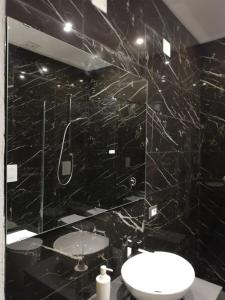 een zwarte badkamer met een wastafel en een spiegel bij Sant Efisio Host in Cagliari