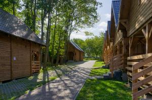 einen Weg zwischen zwei Holzgebäuden mit Bäumen in der Unterkunft Ośrodek Wypoczynkowy Neptun in Władysławowo