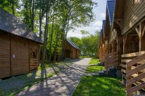 ścieżka między dwoma drewnianymi budynkami z drzewami w obiekcie Ośrodek Wypoczynkowy Neptun we Władysławowie