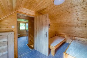drewniany domek z łóżkiem w pokoju w obiekcie Ośrodek Wypoczynkowy Neptun we Władysławowie