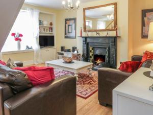 a living room with couches and a fireplace at Church View Cottage in Wooler