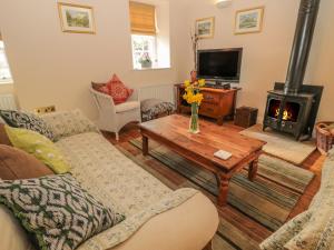 uma sala de estar com um sofá e uma mesa com lareira em The Coach House em Berwick-Upon-Tweed