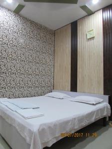 a bedroom with two beds and a wall at Hotel Vrindavan in Fatehpur Sīkri