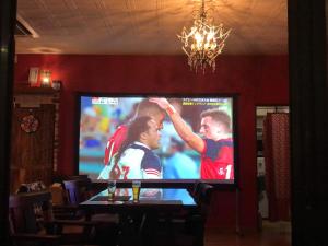 Una pantalla de televisión con un partido de fútbol. en HappyCloset&WasamonHostel, en Kumamoto