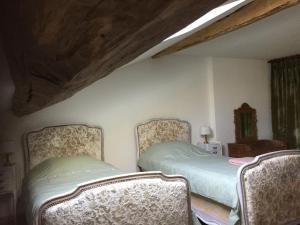 sypialnia z 2 łóżkami i 2 krzesłami w obiekcie Chez Mémère Hélène w mieście Sormonne