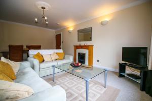 a living room with a couch and a table and a tv at Turnberry Apartments in Turnberry