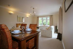 uma sala de estar com uma mesa de madeira e cadeiras em Turnberry Apartments em Turnberry