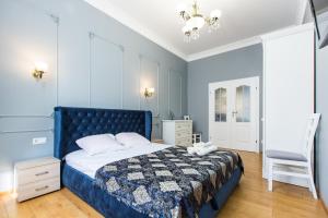 ein Schlafzimmer mit einem blauen Bett und einem Stuhl in der Unterkunft Дизайнерська ВІП квартира по вулиці Куліша 14 in Lwiw
