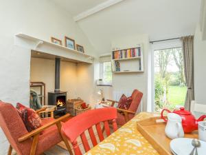 a living room with a table and chairs and a fireplace at Ffrwd Cottage in Bodorgan