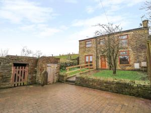 an exterior view of a stone house with a driveway at Moscow Mews in Bradford