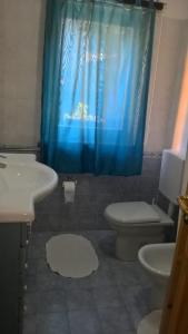 uma casa de banho com um WC e uma cortina de chuveiro azul em Casa Moron em Saint-Vincent