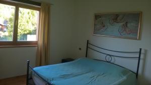 um quarto com uma cama com uma fotografia na parede em Casa Moron em Saint-Vincent