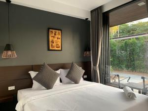 1 dormitorio con 2 camas y ventana grande en The CHESS Samui, en Chaweng