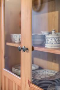 une armoire en verre avec des assiettes et de la vaisselle dans l'établissement Ferienanlage Margaretenhof, à Neujellingsdorf