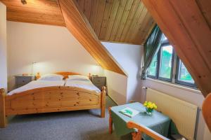 Schlafzimmer mit einem Holzbett und einem Tisch in der Unterkunft Ferienanlage Margaretenhof in Neujellingsdorf