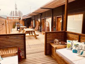 una terraza de madera con bancos y mesas. en DT Loft, en Puerto Natales