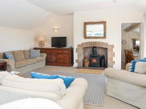 a living room with two couches and a fireplace at Glanrhyd Isaf in Valley
