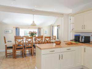 a kitchen and dining room with a table and chairs at Glanrhyd Isaf in Valley