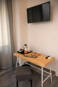 einen Holztisch mit einem TV an der Wand in der Unterkunft PALAZZIELLO MATERDEI in Neapel