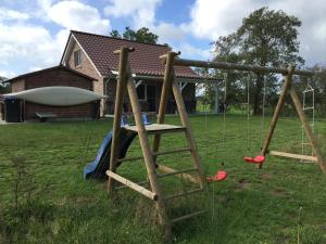 a swing set in the yard of a house at Haus Kornfeld in Oberlangen