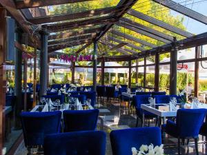 a dining room with blue chairs and tables at Hotel 500 Premium in Zegrze