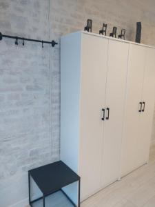 biała szafka z czarną ławką obok w obiekcie Apartament 100 Apartamenty No 1 Ogród w Centrum w Szczecinie +14 zdjęć
