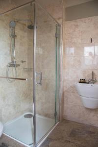 ein Bad mit einer Dusche und einem Waschbecken in der Unterkunft The Evenlode Hotel in Witney