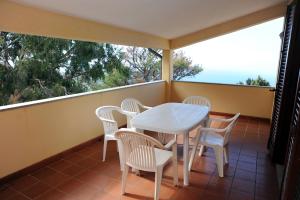 a balcony with a white table and chairs on it at Il Castagno in Marciana