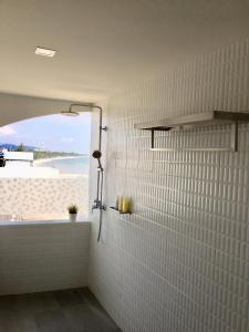 a bathroom with a shower with a view of the beach at PierView Rooms in Hua Hin