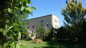 a building with two tables and chairs in a yard at Pension Müllers Mühle in Großenhain