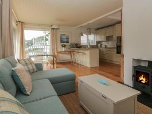 een woonkamer met een blauwe bank en een open haard bij Kittiwake in Plymouth +41 foto's