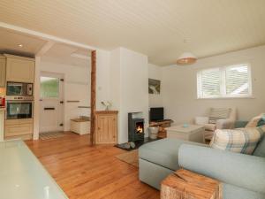 a living room with a blue couch and a kitchen at Kittiwake in Plymouth