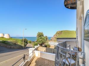 a room with a balcony with a view of the ocean at 10 Cove View in Ilfracombe
