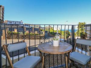 a table and chairs on a balcony with a view of the ocean at 10 Cove View in Ilfracombe