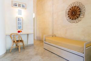 ein Schlafzimmer mit einem Bett, einem Tisch und einem Stuhl in der Unterkunft Hotel Villaggio Cala Di Volpe in Capo Vaticano