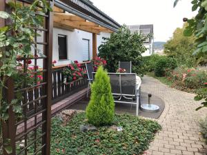 a patio with a table and chairs and flowers at Monteur-/und Ferienwohnung Diehl in Aßlar