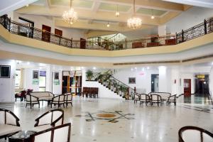 a large room with tables and chairs and a staircase at The Royal Residency in Bodh Gaya