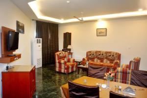 a living room with chairs and a flat screen tv at The Royal Residency in Bodh Gaya