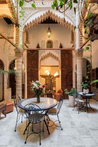 um pátio com uma mesa e cadeiras num edifício em Riad Marhaba em Rabat