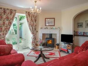 a living room with a red couch and a fireplace at Charlton Lodge in Mawnan