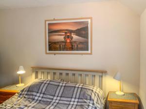 a bedroom with a bed with a picture on the wall at High View Cottage in Castleton