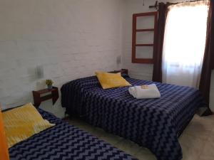 a bedroom with two beds and a window at Remanso Apart Hotel in Termas del Daymán